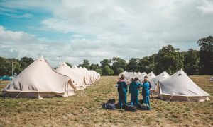 Festivalgoers in overalls find their yurts. Photograph: Khris Cowley for Here & Now 